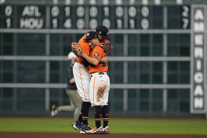 Houston Astros shortstop Carlos Correa and second baseman Jose Altuve hug after Game 2 of baseball's World Series between the Houston Astros and the Atlanta Braves Wednesday, Oct. 27, 2021, in Houston. The Astros won 7-2, to tie the series 1-1. (AP Photo/David J. Phillip)