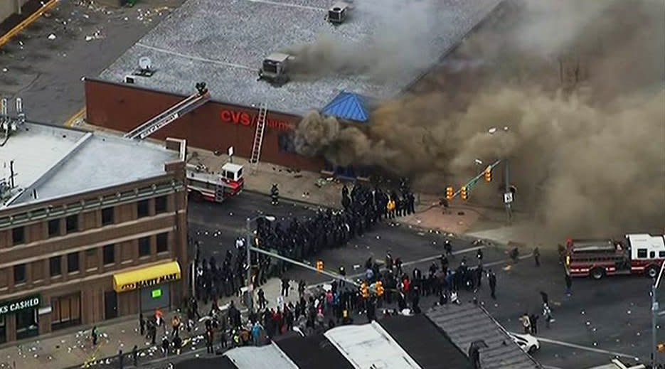 In this frame from video provided by WJLA, smoke rises from a store Monday, April 27, 2015, during unrest following the funeral of Freddie Gray in Baltimore. Rioters plunged part of Baltimore, torching a pharmacy, setting police cars ablaze and throwing bricks at officers. (WJLA via AP) MANDATORY CREDIT