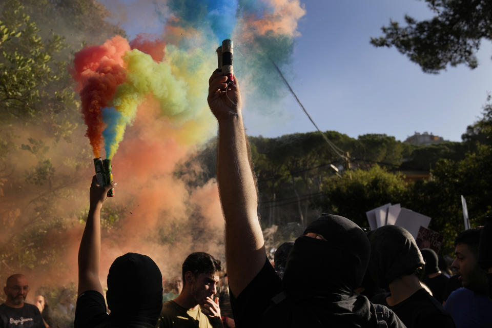Lebanese-Armenian protesters hold flares with the colors of their nation's flag, near the Azerbaijani Embassy, to denounce the Azerbaijani military offensive that recaptured Nagorno-Karabakh from the separatist Armenian authorities in the enclave, in Ain Aar, east of Beirut, Lebanon, Thursday, Sept. 28, 2023. A 24-hour Azerbaijani blitz last week forced Armenian separatist authorities to sit down for talks on Nagorno-Karabakh's "reintegration" into Azerbaijan. (AP Photo/Hussein Malla)