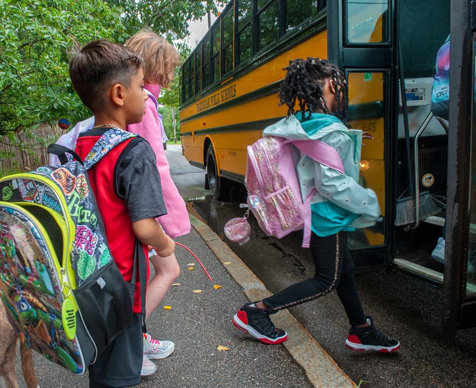 Students board a school bus on the first day of school in Framingham, Aug. 30, 2023.