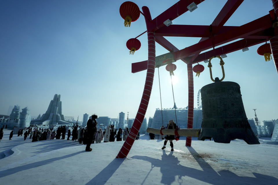 Visitors line-up to hit a giant drum against the ice structures at the Harbin Ice and Snow World in Harbin, China's Heilongjiang province on Monday, Jan. 6, 2025. (AP Photo/Andy Wong)