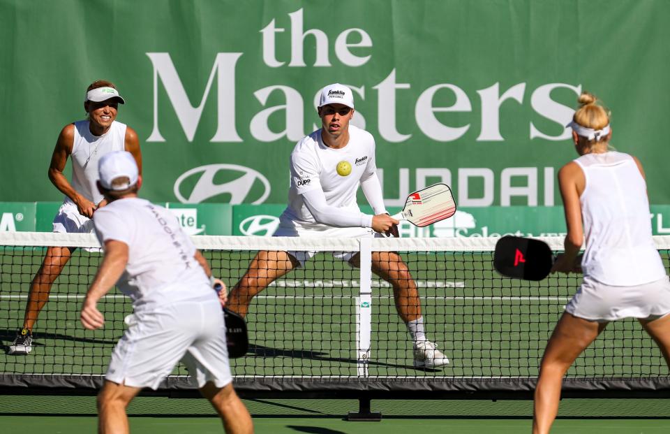 Professional player Ben Johns returns a ball while playing mixed doubles with teammate Simone Jardim during the Pro Pickleball Association Masters tournament at the La Quinta Resort and Club, Friday, Nov. 12, 2021, in La Quinta, Calif. 