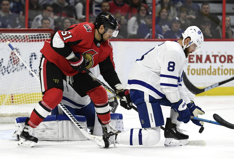 Toronto Maple Leafs defenseman Jake Muzzin (8) uses his glove to keep an incoming puck away from Ottawa Senators center Artem Anisimov (51) and Maple Leafs goaltender Jack Campbell (36) during first-period NHL hockey game action in Ottawa, Ontario, Saturday, Feb. 15, 2020. (Justin Tang/The Canadian Press via AP)