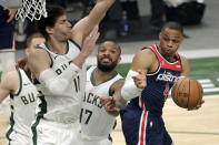 Washington Wizards' Russell Westbrook passes the ball around multiple Milwaukee Bucks defenders during the first half of an NBA basketball game Wednesday, May 5, 2021, in Milwaukee. (AP Photo/Aaron Gash)