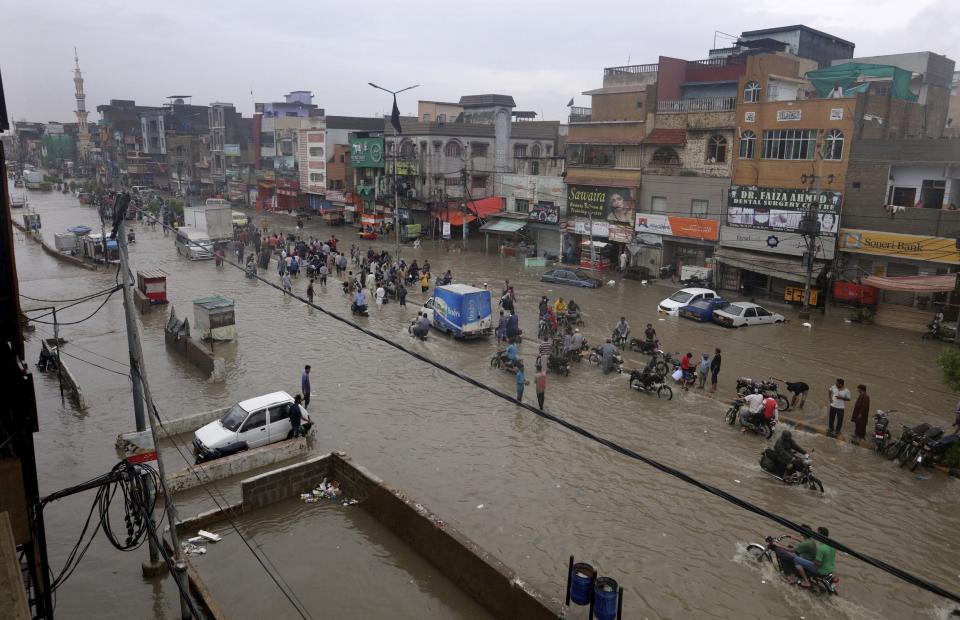 Vehicles drive through a flooded road after heavy monsoon rains, in Karachi, Pakistan, Thursday, Aug. 27, 2020. Heavy monsoon rains have lashed many parts of Pakistan as well the southern port city of Karachi, leaving flooding streets, damaging homes and displacing scores of people. (AP Photo/Fareed Khan)