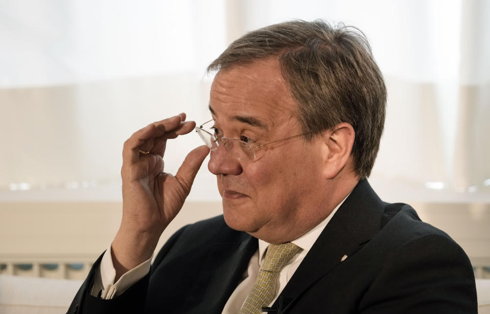 Governor of North Rhine-Westphalia Armin Laschet adjusts his glasses as he speaks during an interview with the Associated Press in his office in Duesseldorf, Germany, Wednesday, June 30, 2021. Laschet, the 60-year-old governor of Germany's most populous state, is the front-runner to succeed Angela Merkel as chancellor in the country's Sept. 26 election. (AP Photo/Martin Meissner)