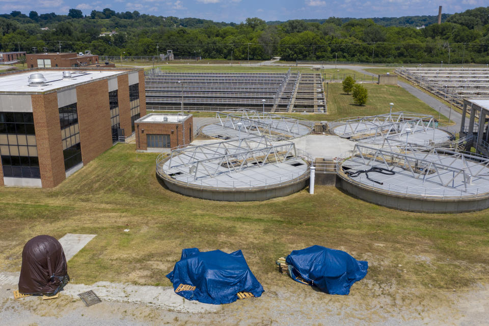 Confederate statues are covered in tarps while being stored at a waste water treatment plant near downtown Tuesday July 14, 2020, in Richmond, Va. The city of Richmond removed several of the statues along Monument Ave. where they will be stored until suitable sites can be found for them. (AP Photo/Steve Helber)