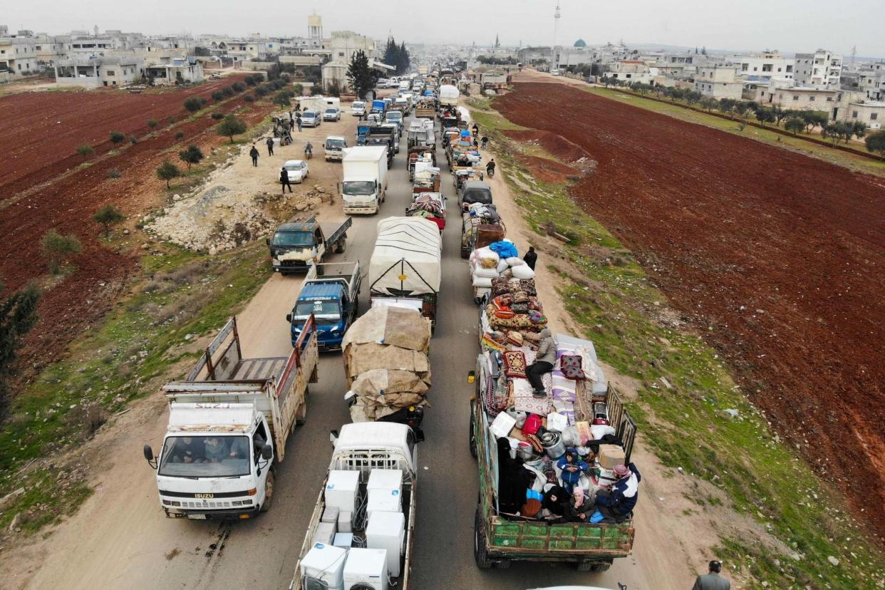 A aerial photo shows displaced Syrians driving through Hazano in the northern countryside of Idlib, after fleeing on January 28, 2020 its southern countryside towards areas further north near the border with Turkey, as a result of an ongoing offensive by regime forces on Syria's rebel-held northwestern region: AFP via Getty Images