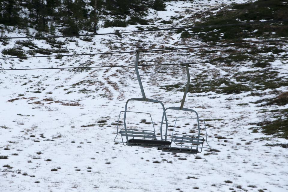 Lift chairs hang idly from their cables at Hoodoo Ski Area where a lack of snow has delayed the ski season.