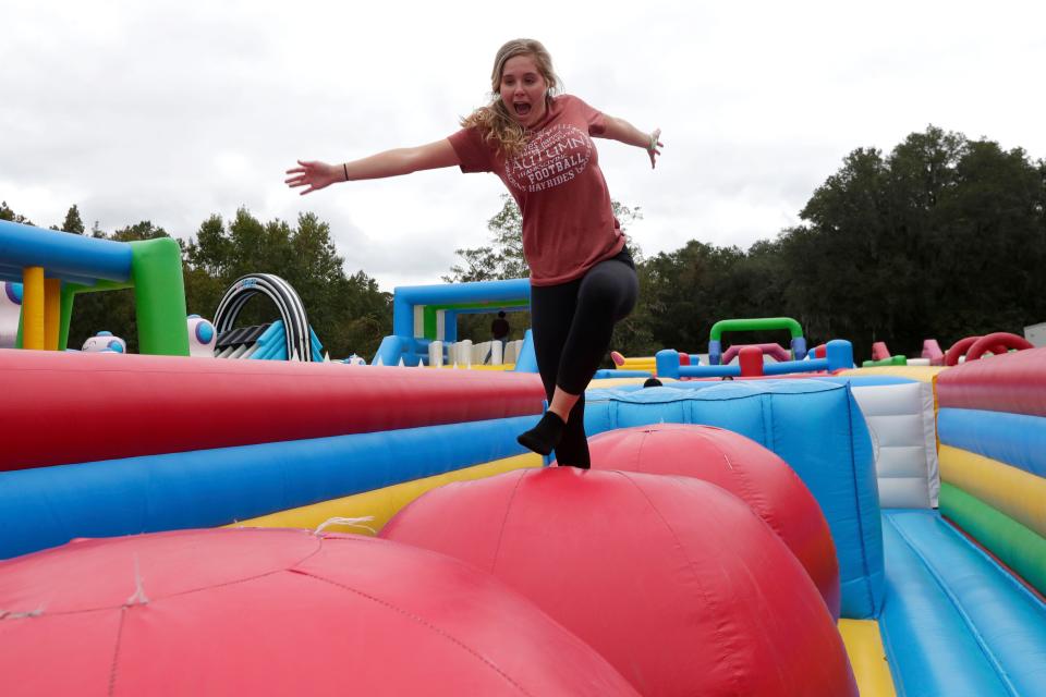 Lindsay Anders tests her balance as she races across an obstacle in "The Giant," a 900-foot inflatable obstacle course.