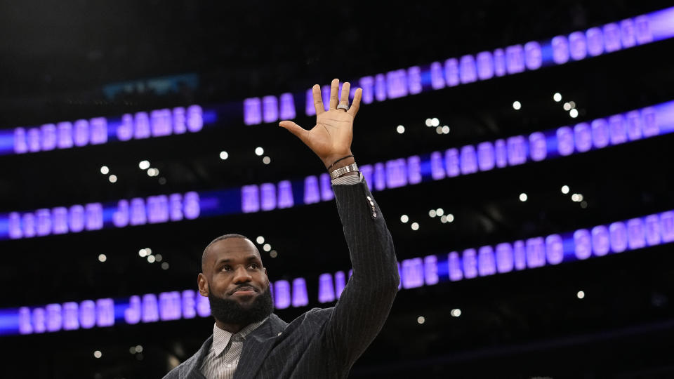 Los Angeles Lakers forward LeBron James waves to fans during a ceremony honoring him as the NBA's all-time leading scorer before an NBA game against the Milwaukee Bucks on Thursday, Feb. 9, 2023, in Los Angeles. James passed Kareem Abdul-Jabbar to earn the record during Tuesday's NBA game against the Oklahoma City Thunder. (AP Photo/Mark J. Terrill)