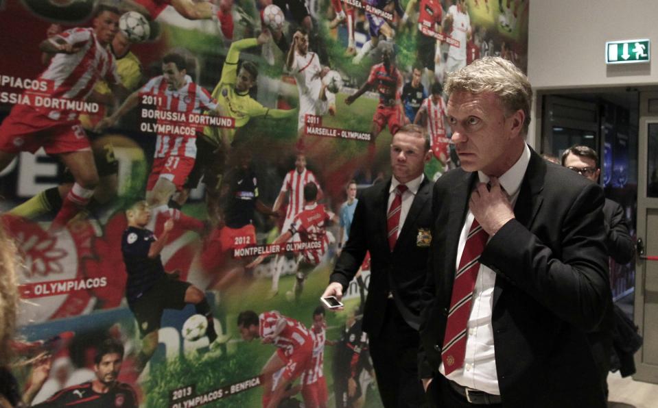 Manchester United's coach David Moyes, right, and player Wayne Rooney arrive for a news conference at Georgios Karaiskakis stadium, in Piraeus port, near Athens, on Monday, Feb. 24, 2014. Manchester United will play against Olympiakos in the Champions League's round of 16 on Tuesday. (AP Photo/Thanassis Stavrakis)