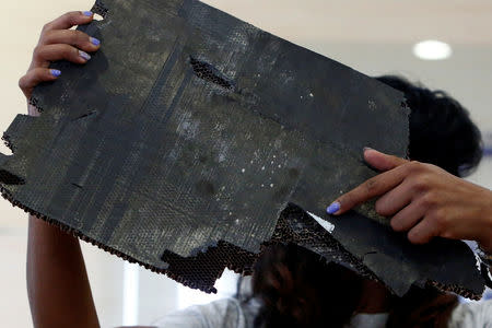 Grace Nathan, whose mother was onboard the missing Malaysia Airlines flight MH370, displays debris believed to belong to MH370 before handing over to Malaysia's Transport Minister Anthony Loke Siew Fook in Putrajaya, Malaysia November 30, 2018. REUTERS/Lai Seng Sin