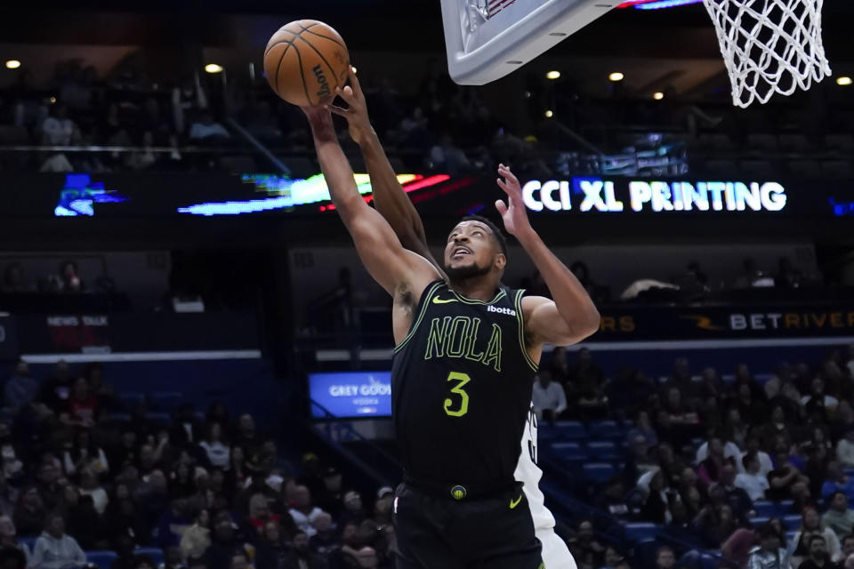 New Orleans Pelicans guard CJ McCollum (3) pulls down a rebound against Brooklyn Nets center Nic Claxton in the first half of an NBA basketball game in New Orleans, Tuesday, Jan. 2, 2024. (AP Photo/Gerald Herbert)