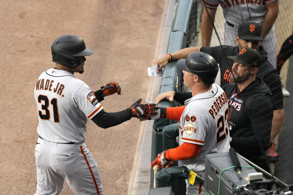 San Francisco Giants' LaMonte Wade Jr. (31) is greeted at the dugout by Joc Pederson (23) after Wade Jr.'s home run off Chicago Cubs starting pitcher Kyle Hendricks during the first inning of a baseball game Tuesday, Sept. 5, 2023, in Chicago. (AP Photo/Charles Rex Arbogast)