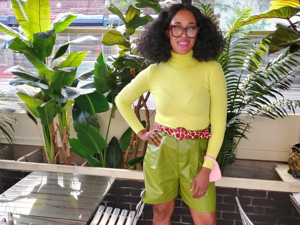 sandra wearing a yellow shirt and green leather shorts