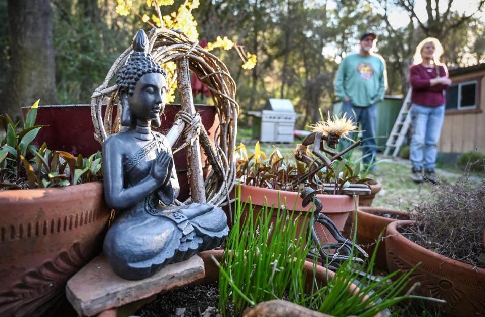 A Gautama Buddha statue and peace sign made of tree trimmings are among the items put aside to move by longtime El Portal Trailer Park residents Neal and Nancy Dawson on Sunday, March 13, 2022.