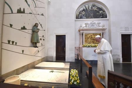 Pope Francis prays on the grave of two of the three little sheperd at the Shrine of Our Lady of Fatima in Portugal May 13, 2017. Osservatore Romano/Handout via REUTERS