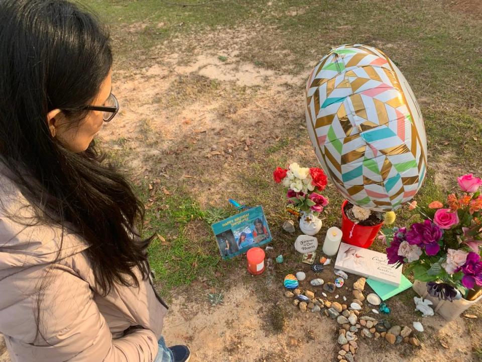Rebecca Lara looks down on a memorial dedicated to her daughter Gisele Lara who was killed in an apparent murder-suicide on the campus of Columbus State University.
