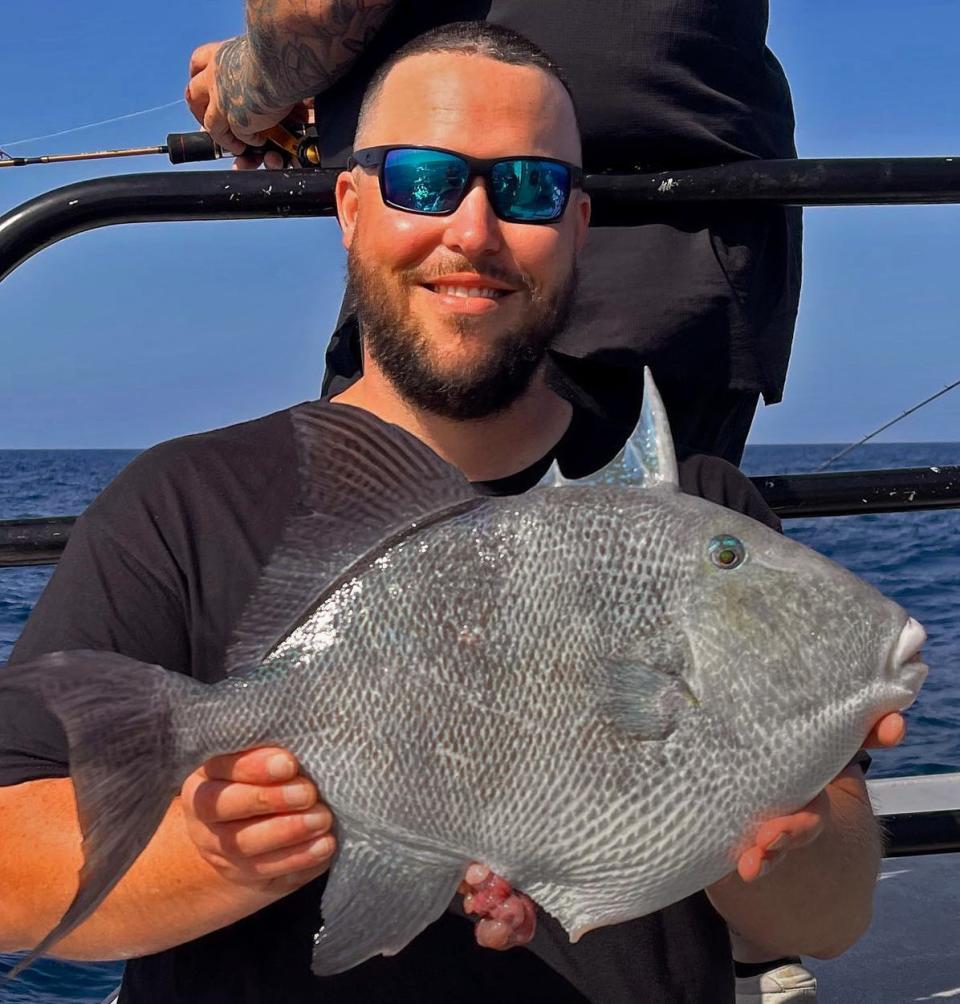 Capt. Dylan Hubbard of Hubbard's Marina, shows off a gray triggerfish caught offshore out of JohnÕs Pass at  Madeira Beach on Tuesday. 