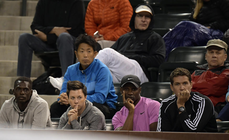 Jermaine Jenkins, lower left corner, coach of Naomi Osaka, of Japan, watches the match against Belinda Bencic from the coaching box at the BNP Paribas Open tennis tournament Tuesday, March 12, 2019 in Indian Wells, Calif. (AP Photo/Mark J. Terrill)