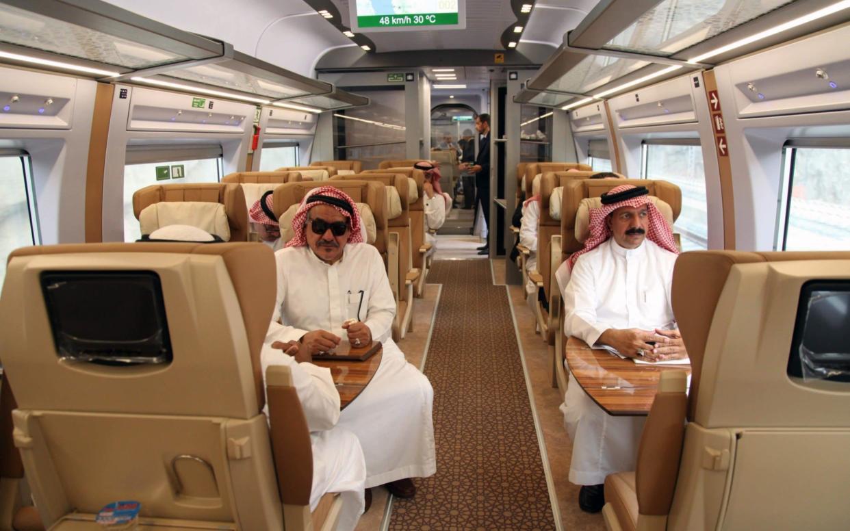 Saudi officials sitting in a high-speed train, ahead of their trip, at a station in Saudi Arabia's holy city of Mecca - AFP