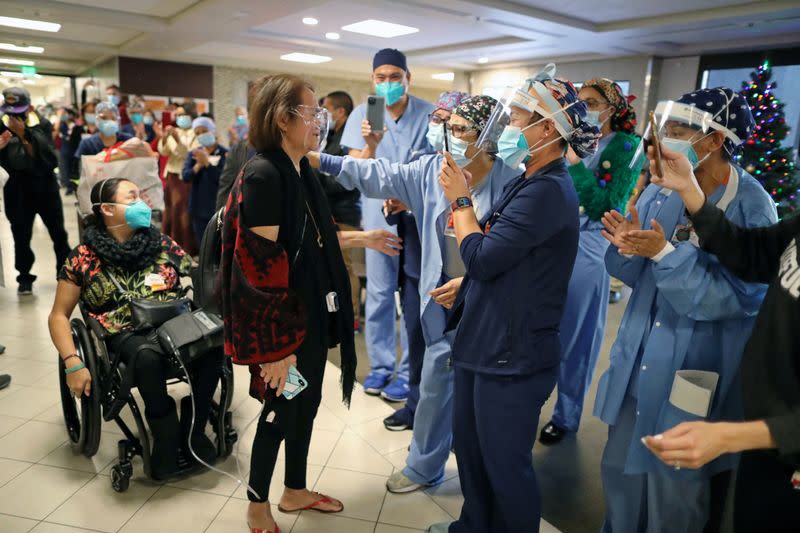 Intensive Care Unit Nurse Merlin Pambuan, is cheered by hospital staff as she walks out of the hospital where she spent 8 months with the coronavirus disease (COVID-19), at Dignity Health in Long Beach