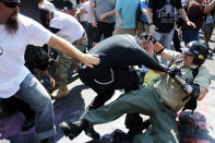 <p>White nationalists, neo-Nazis and members of the ‘alt-right’ clash with counter-protesters as they enter Lee Park during the ‘Unite the Right’ rally August 12, 2017 in Charlottesville, Virginia. After clashes with anti-fascist protesters and police the rally was declared an unlawful gathering and people were forced out of Lee Park, where a statue of Confederate General Robert E. Lee is slated to be removed. (Photo: Chip Somodevilla/Getty Images) </p>