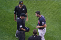 Atlanta Braves starter Kyle Muller, right, reacts as third base umpire Ron Kulpa (46) asks to see what is beneath his belt after he pitched during the first inning of a baseball game against the New York Mets, Monday, June 21, 2021, in New York. (AP Photo/Kathy Willens)