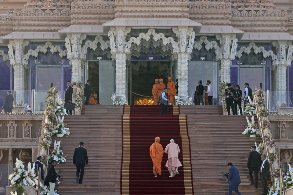 Indian Prime Minister Narendra Modi, center right, walks up the carpeted steps with Hindu priest Brahmaviharidas Swami after arriving for the opening ceremony of the first stone-built Hindu temple in the Middle East, belonging to Bochasanwasi Akshar Purushottam Swaminarayan Sanstha in Abu Mureikha, 40 kilometers (25 miles) northeast of Abu Dhabi, United Arab Emirates, Wednesday, Feb. 14, 2024. (AP Photo/Kamran Jebreili)