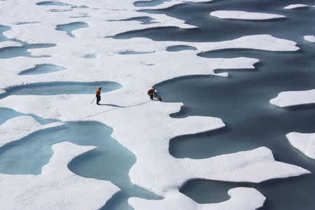 FILE PHOTO: The crew of the U.S. Coast Guard Cutter Healy, in the midst of their ICESCAPE mission, retrieves supplies in the Arctic Ocean in this July 12, 2011 NASA handout photo. Kathryn Hansen/NASA via REUTERS/File Photo
