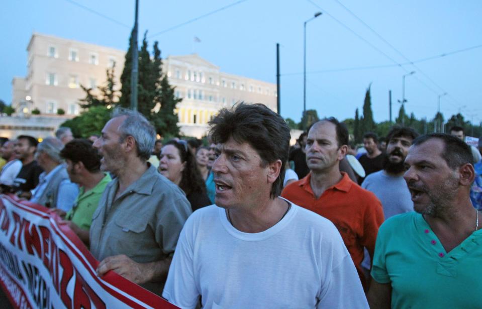 Protesting steelworkers chant anti-government slogans in front of parliament, on Monday, July 23, 2012. Police forced an end to a strike lasting nearly four months at a steel plant near Athens last week. The action triggered a political spat between the country's new conservative-led government and leftwing opposition parties ahead of a new visit to Athens this week by international debt inspectors. (AP Photo/Thanassis Stavrakis)