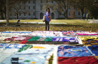 <p>Student Christina Batipps browses over a display of AIDS memorial quilt panels on display as part of World AIDS Day at Emory University, Dec. 1, 2014, in Atlanta. (AP Photo/David Goldman) </p>