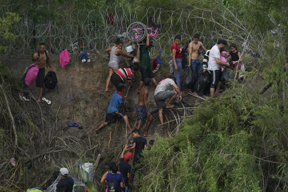 Migrants walk up the bank on the U.S. side of the Rio Grande river, as seen from Matamoros, Mexico, Wednesday, May 10, 2023. Asylum seekers have been showing up at the US-Mexico border in huge numbers in anticipation of the restriction of Title 42, that had allowed the government to quickly expel migrants to Mexico. New measures were announced Wednesday creating new legal pathways for migrants. (AP Photo/Fernando Llano)