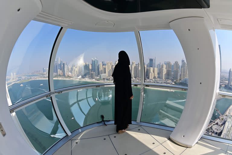 Una mujer observa Dubai desde el interior de una cápsula del Dubai Eye (Ain Dubai), la noria de observación más grande y alta del mundo, situada en la ciudad emiratí, cerca del puerto deportivo de Dubai, el 21 de octubre de 2021.