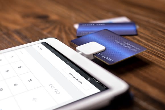 A credit card reader attached to a mobile device, with several credit cards