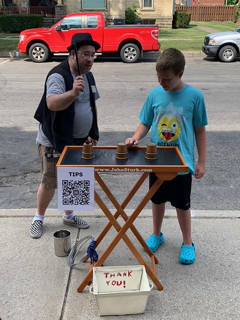 Nathan Secord, 12, helps magician John Sturk during a street performance Wednesday in downtown Colon at Abbott's Magic Get-Together, which continues through Saturday.