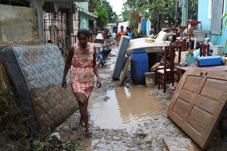 A woman walks in front of a house flooded by the overflow the Soco River in the aftermath of Hurricane Maria in El Seibo, Dominican Republic, September 22, 2017. REUTERS/Ricardo Rojas