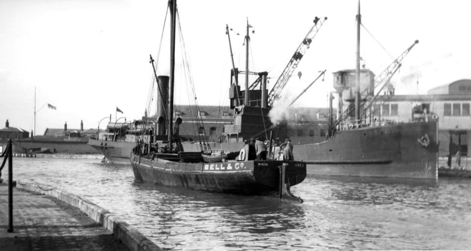 A long gone scene at the Camber, Old Portsmouth.With a collier tied up alongside the Camber dock we see a steam vessel making her way out to the harbour. Picture: Barry Cox collection