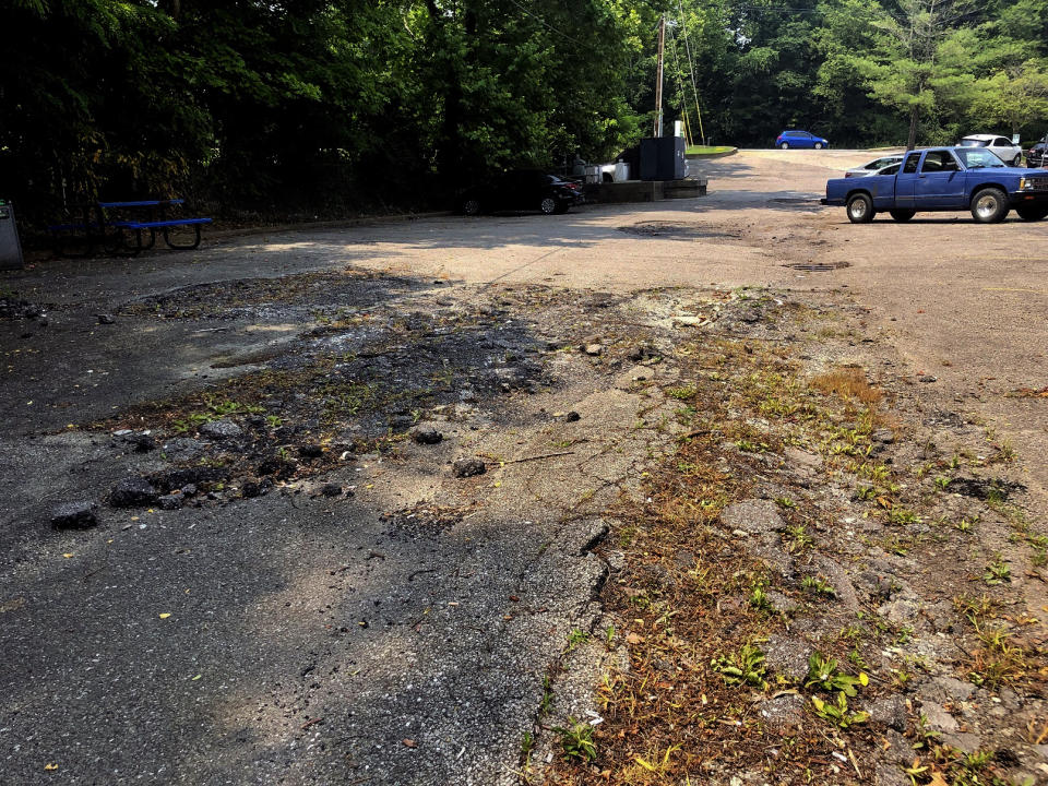 A crumbling parking lot at the Prestera Center headquarters is shown Wednesday, July 21, 2021 in Huntington, W. Va. In one of the epicenters of the U.S. opioid explosion, the nonprofit mental health and addiction treatment provider really could use some money. Whether from a potential national settlement deal with big U.S. drug distribution companies or from some other source, an infusion of cash would help stem the tide of losses in staffing and other areas in recent years, along with the strain caused by the coronavirus pandemic. (AP Photo/John Raby)