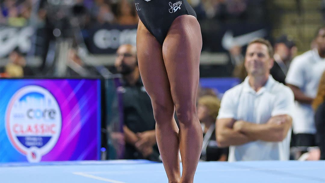 a woman in a leotard doing a gymnastics trick