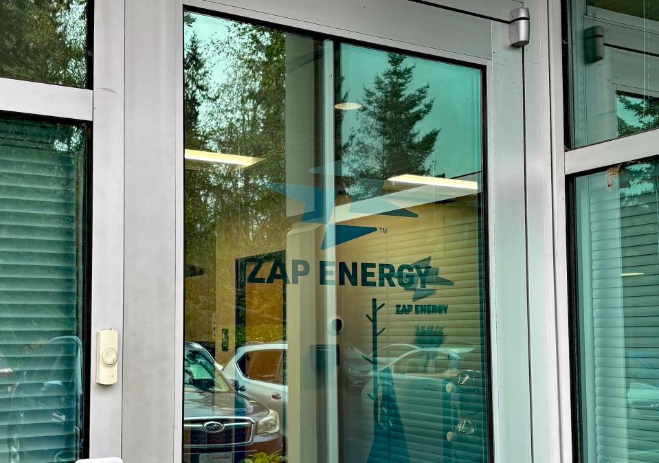 A glass door with the words Zap Energy on it