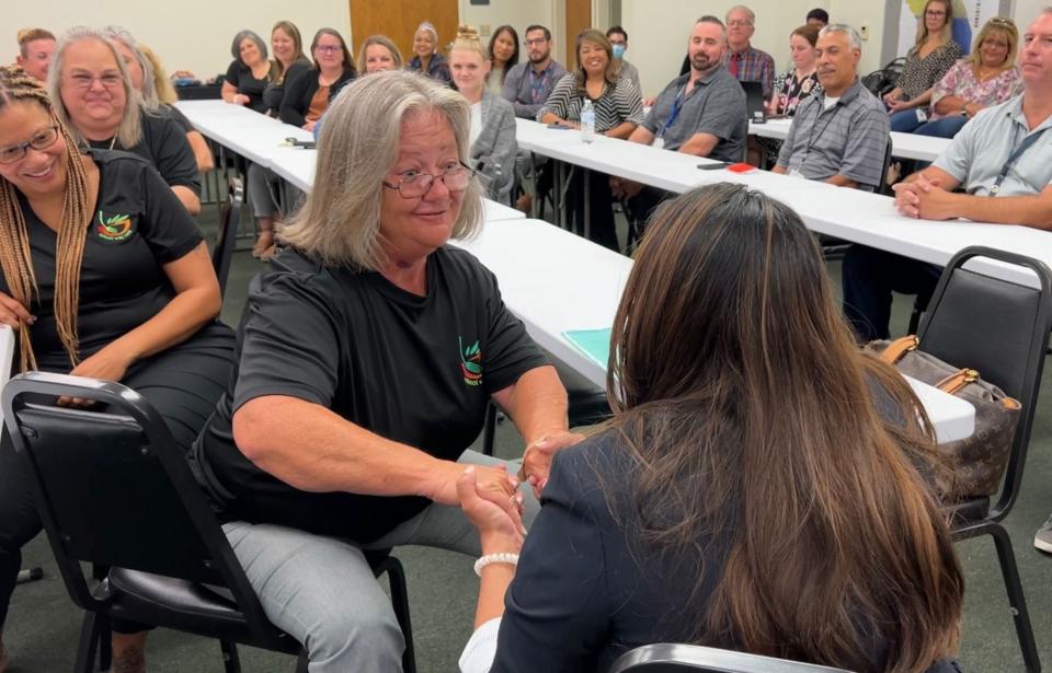 New Volusia County Schools Superintendent Carmen Balgobin, pictured from behind, embraces hands with Teresa Ashcraft, an area manager of School Way Café, during a July 7 meeting at the Olson Facilities Services Building in Daytona Beach. Balgobin is attempting to meet many of the 7,600 employees in the district.