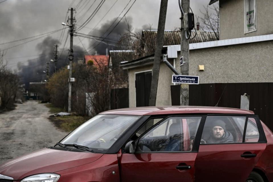 Un hombre observa desde la parte trasera de un auto en la ciudad de Stoianka, al oeste de Kyiv (AFP via Getty Images)