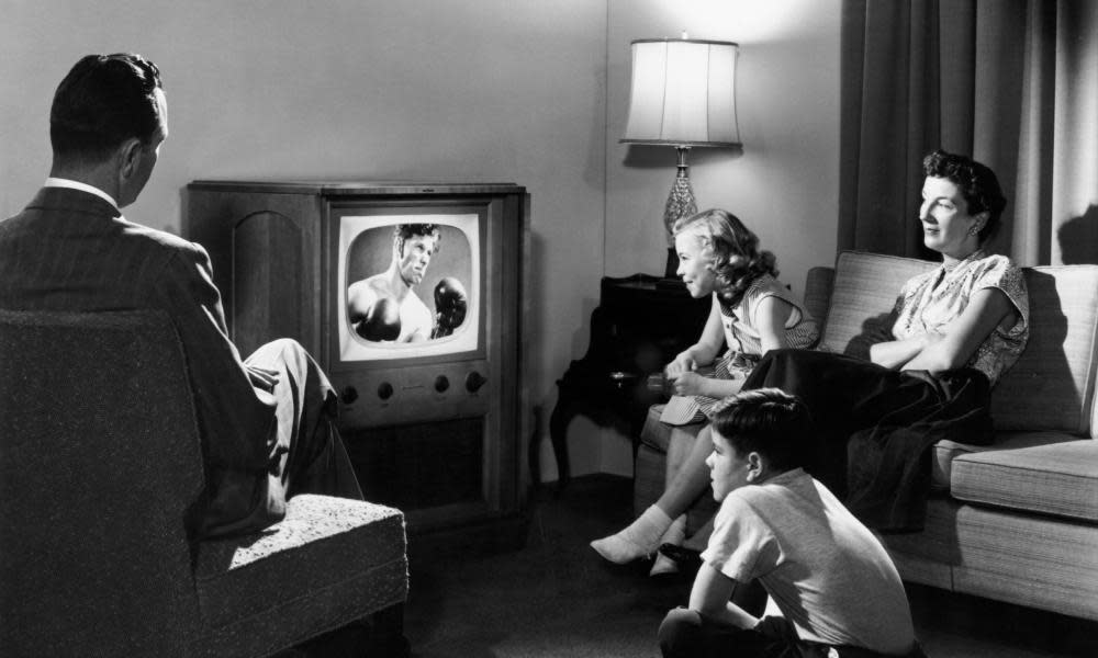 A family watching a boxing match on television in their home, circa 1950.