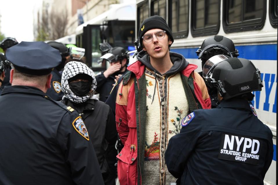 Multiple individuals are detained by NYPD officers at Columbia University. Matthew McDermott