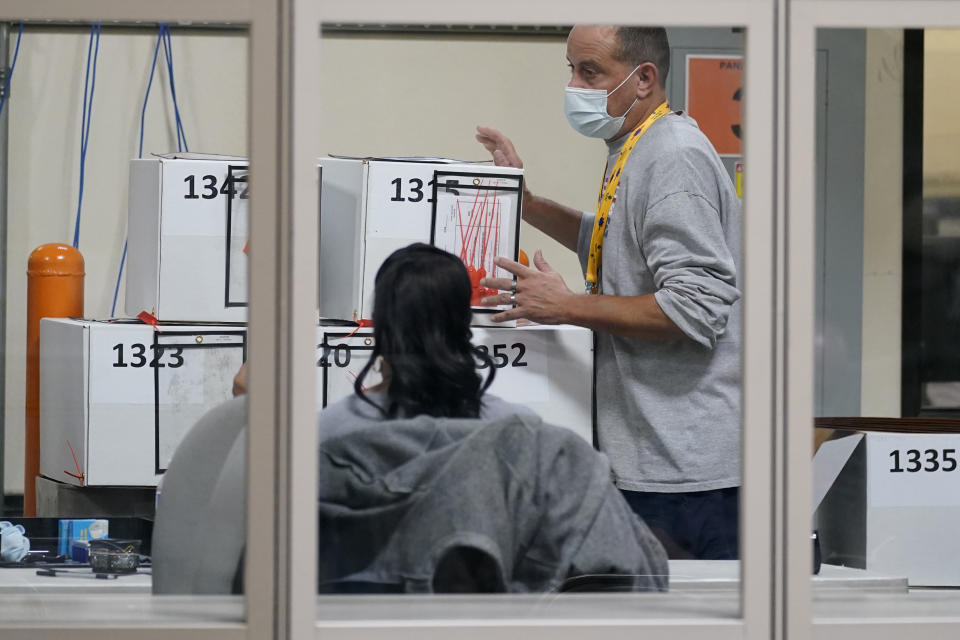 FILE - In this Nov. 5, 2020 file photo, a county election worker moves boxes of mail-in ballots at a tabulating area at the Clark County Election Department in Las Vegas. County officials in Nevada began signing off Monday, Nov. 16 on results of the Nov. 3 election that gave Democratic candidate Joe Biden a 33,596-vote statewide victory over Republican Donald Trump in the presidential contest. The former vice president drew a little over 50% of the vote and Trump a little under 48% in unofficial results submitted for approval by commissioners in counties including Washoe, surrounding Reno, and Clark, which encompasses Las Vegas. (AP Photo/John Locher, File)