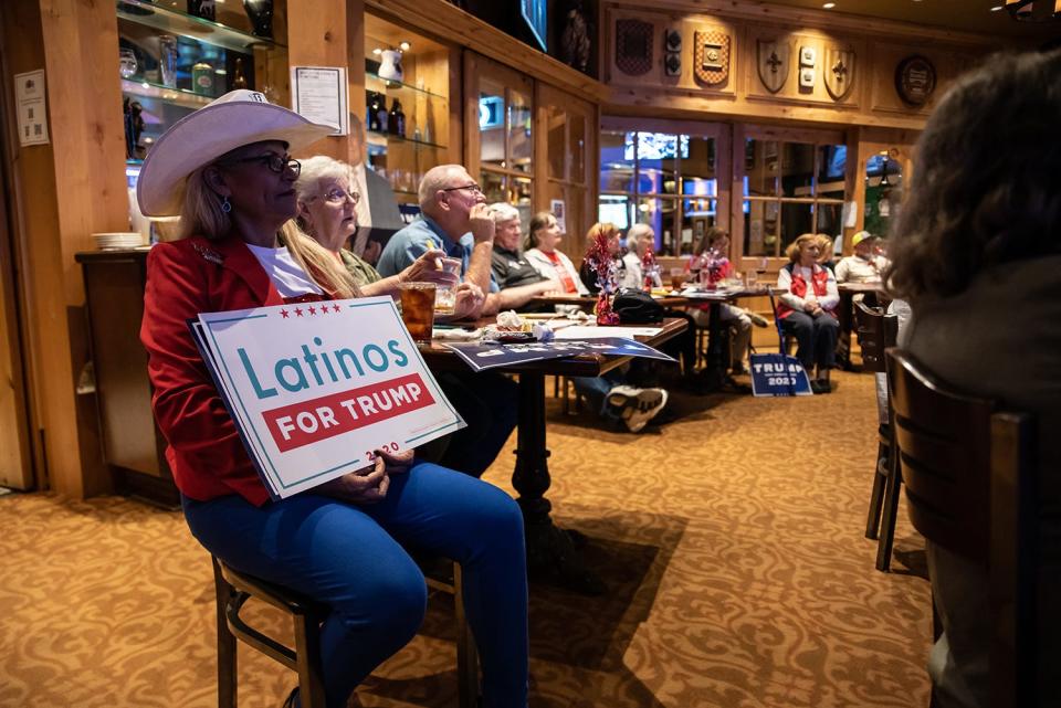 A woman holds a "Latinos for Trump" sign at a watch party for the final presidential debate between President Donald Trump and former Vice President Joe Biden on October 22, 2020, in San Antonio, Texas.