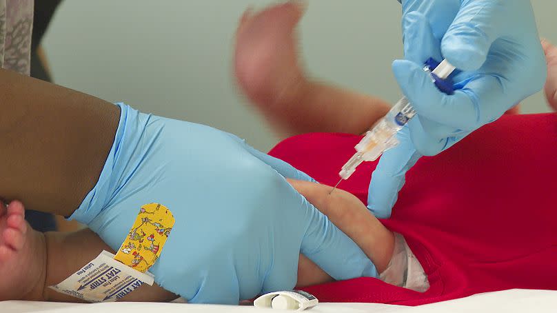 An infant receives a routine vaccination.