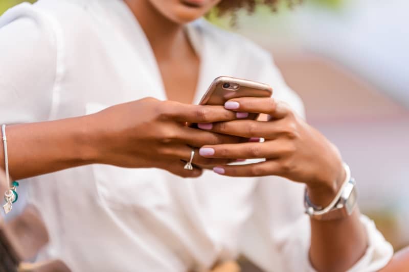 Outdoor portrait of young black African American young woman talking on mobile phone